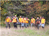 Group of People Walking through Grass