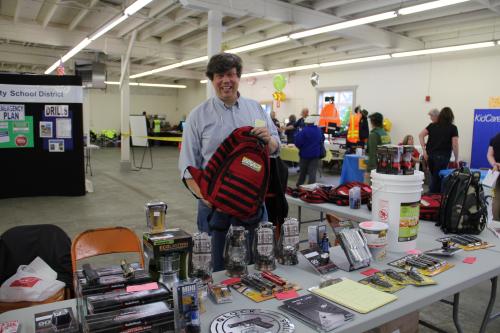 Readiness Fair Newport 2014 - Man Smiling While Holding Red Backpack