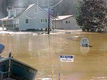Homes and Signs Under Water Impacted by Flooding