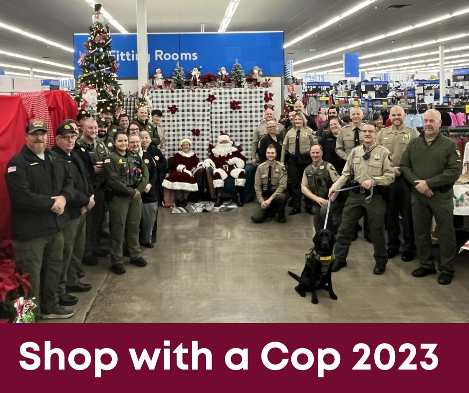 Group of law enforcement smiling during shop with a cop event. 