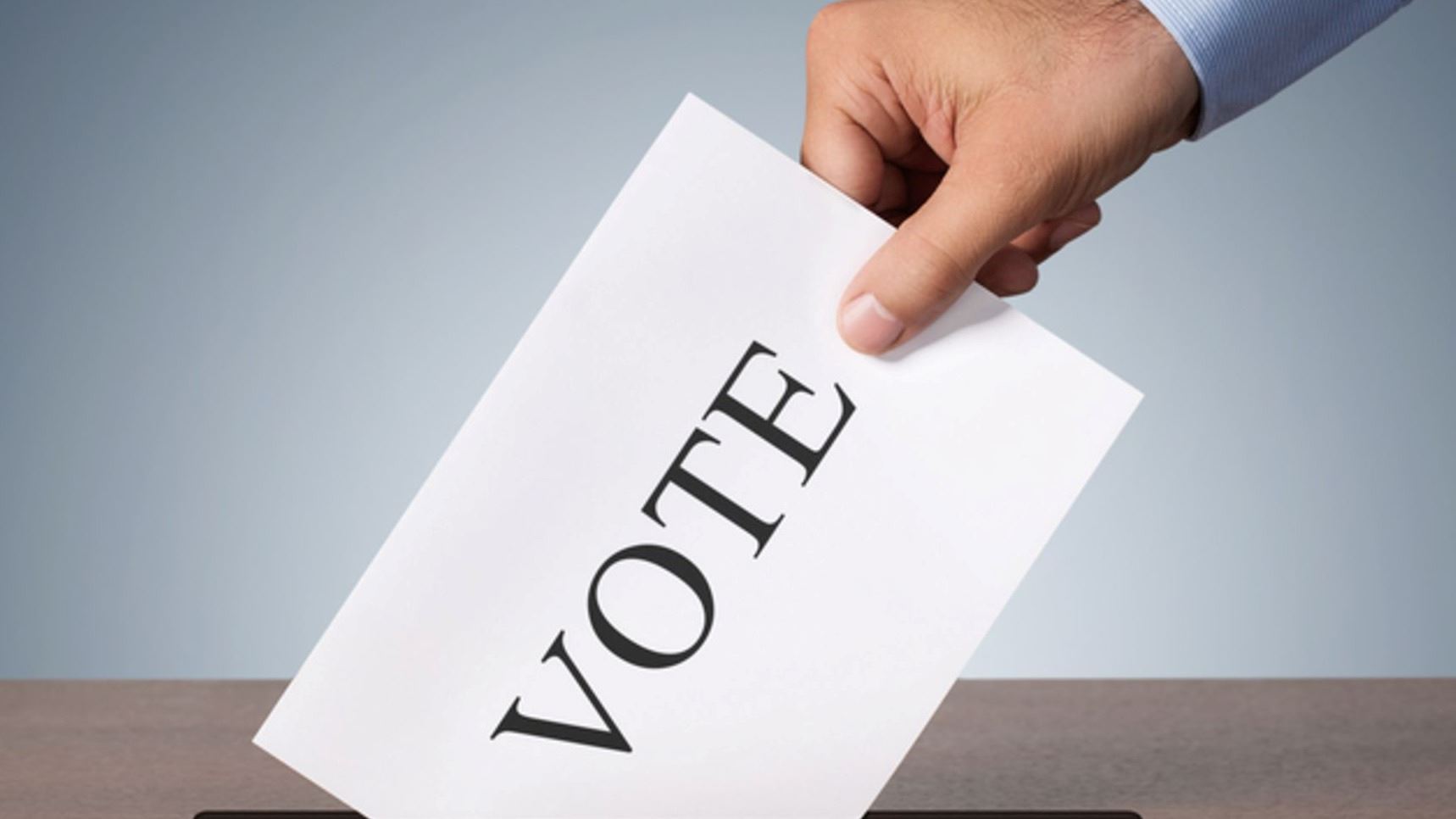 Man Putting Vote Card in Ballot Box