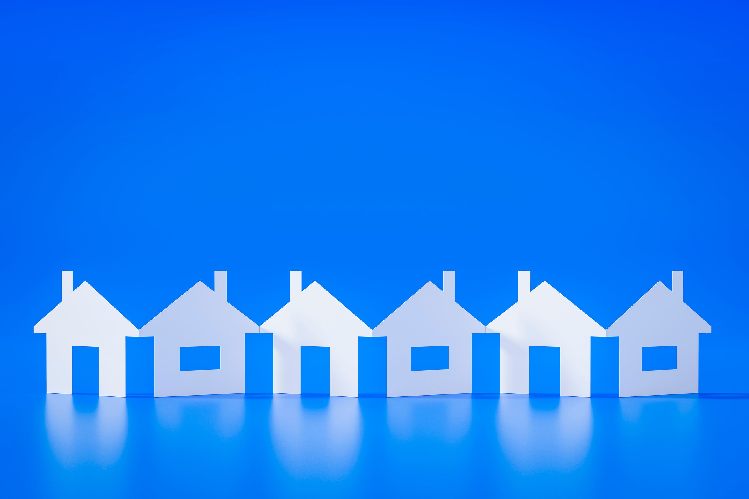 paper cutouts of white houses on blue background