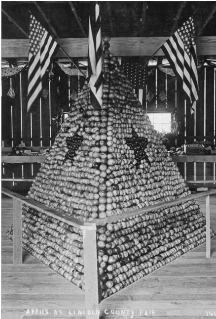 A tall stack of apples at an early 19th century Lincoln County Fair