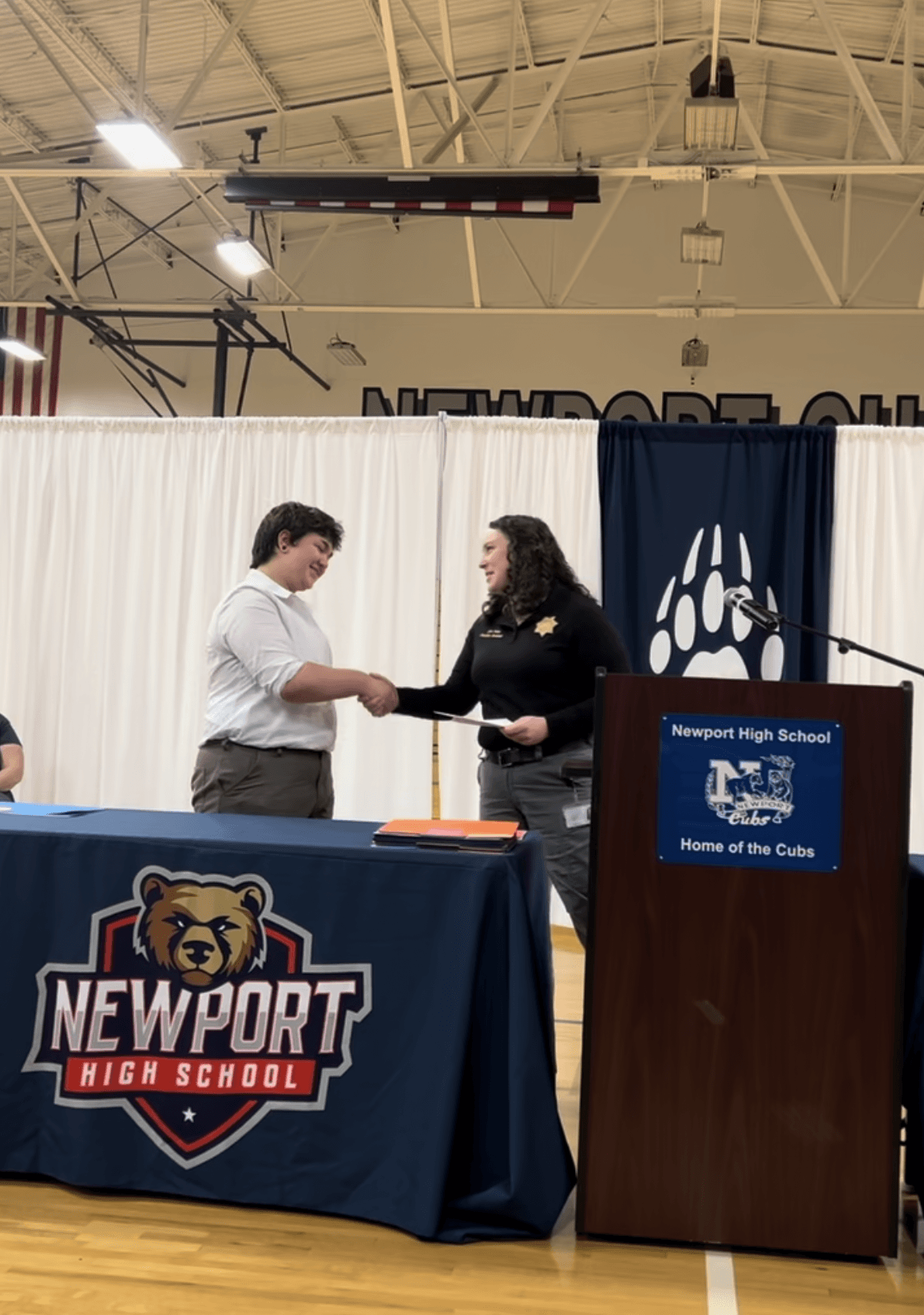 Two people shaking hands at a scholarship presentation. 